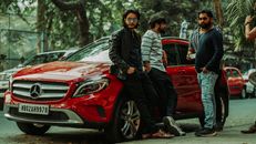 Men Standing Beside a Red Car