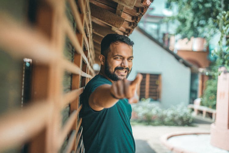 Man Standing In Backyard And Pointing With Finger