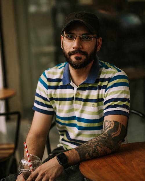 Free A Tattooed Man in Striped Polo Shirt  Stock Photo
