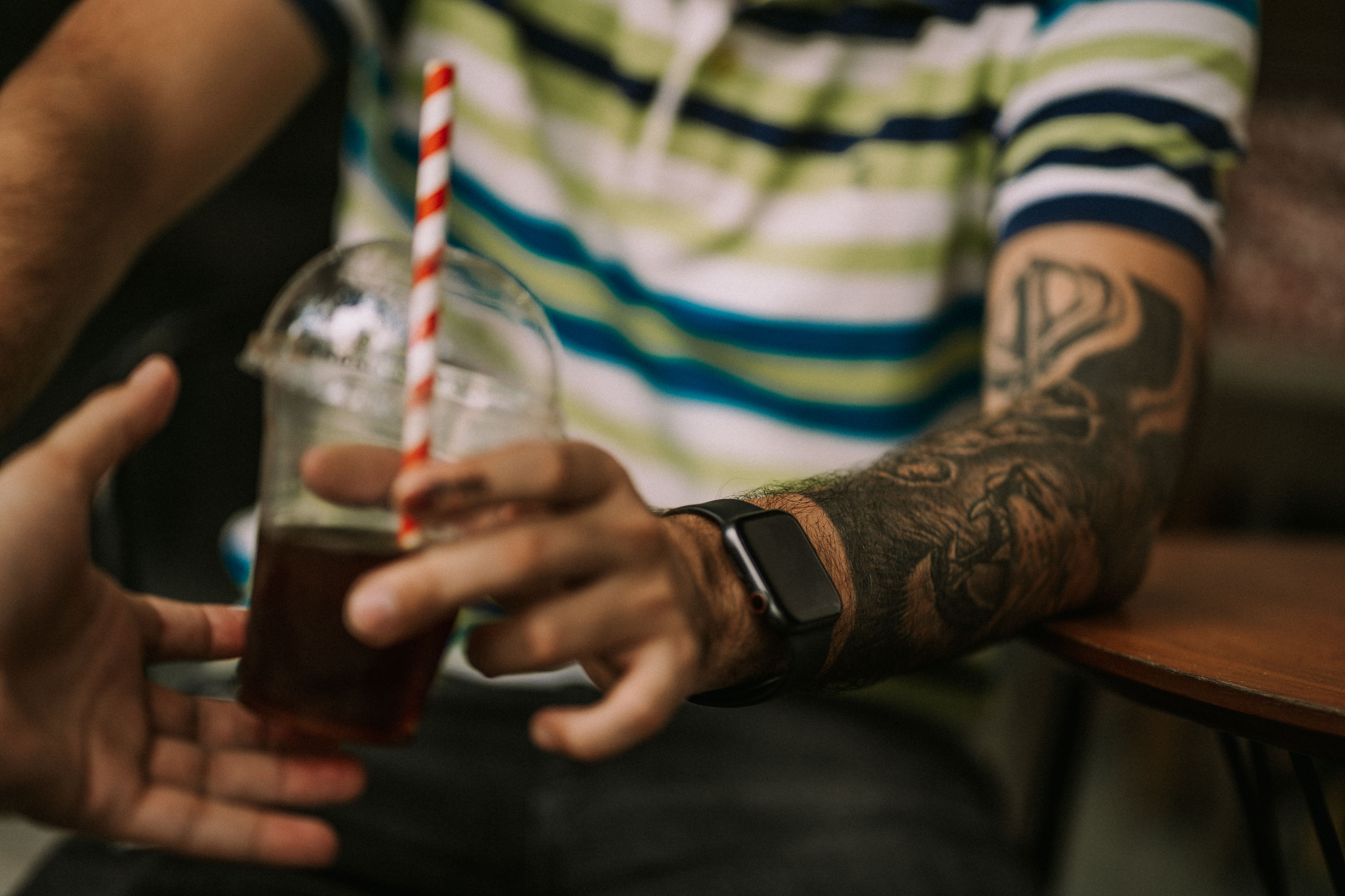 Pria memegang gelas kopi susu es di trotoar depan kantor