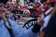 Colorful parade with drummers in face paint, celebrating in Muri, Switzerland.