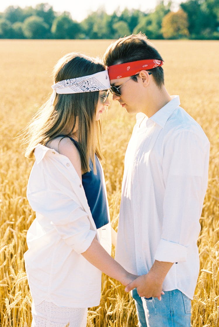 Couple Standing In Wheat Field Touching Foreheads