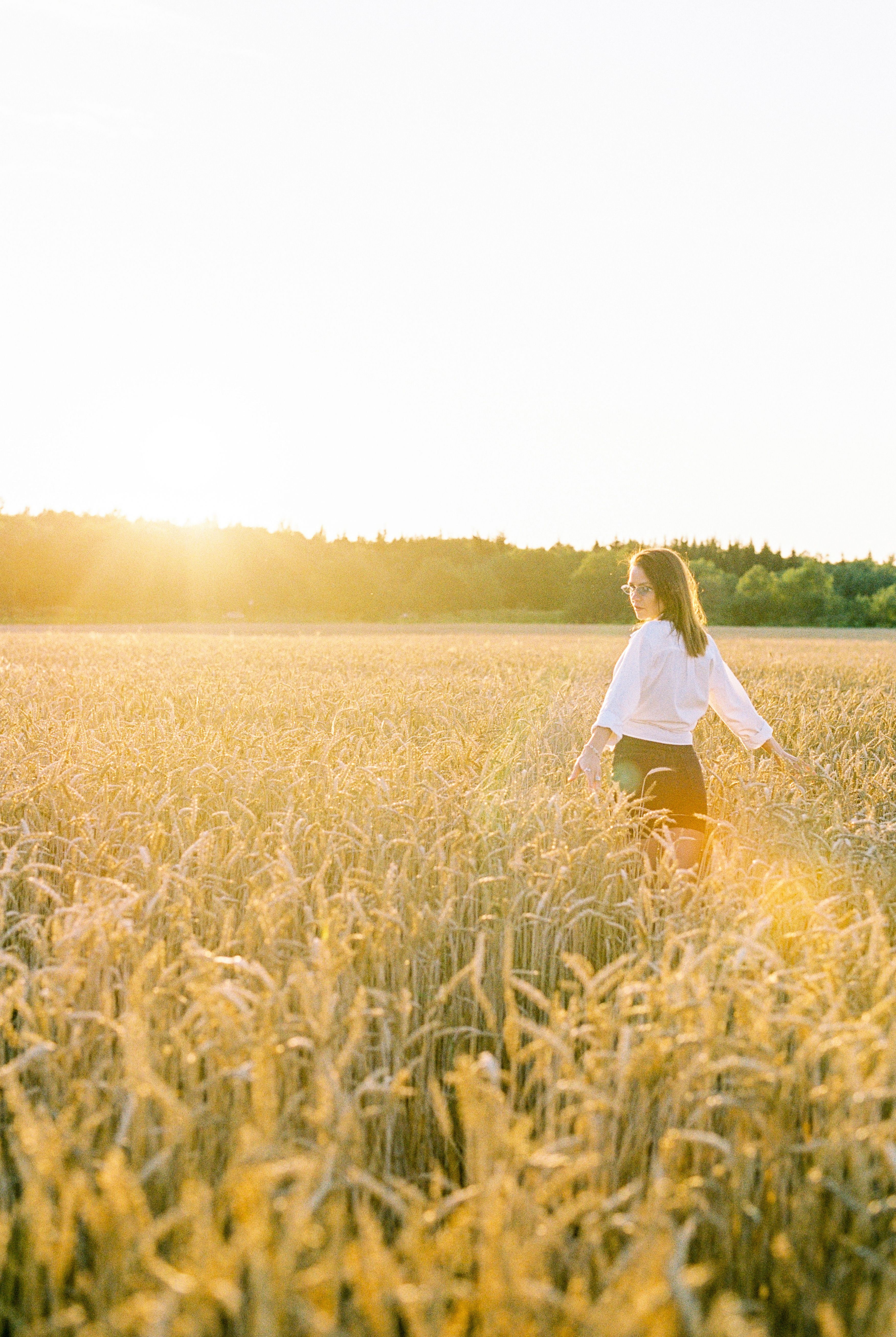 A Woman in White Long Sleeves Standing on a Wheat Field · Free Stock Photo