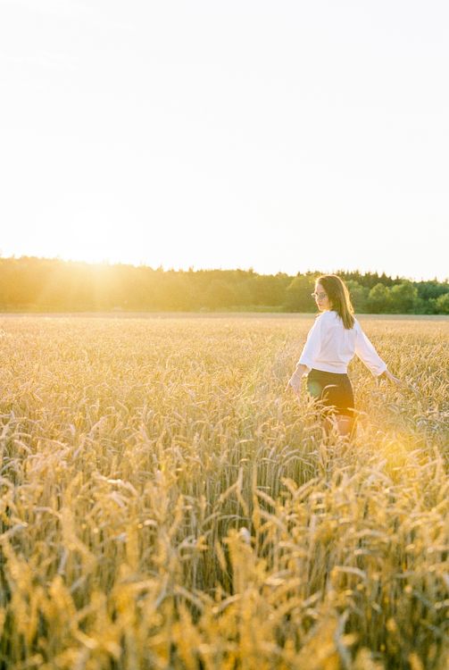 A Woman in White Long Sleeves Standing on a Wheat Field · Free Stock Photo