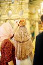 Woman Putting Crown on Top of Orthodox Bride Head