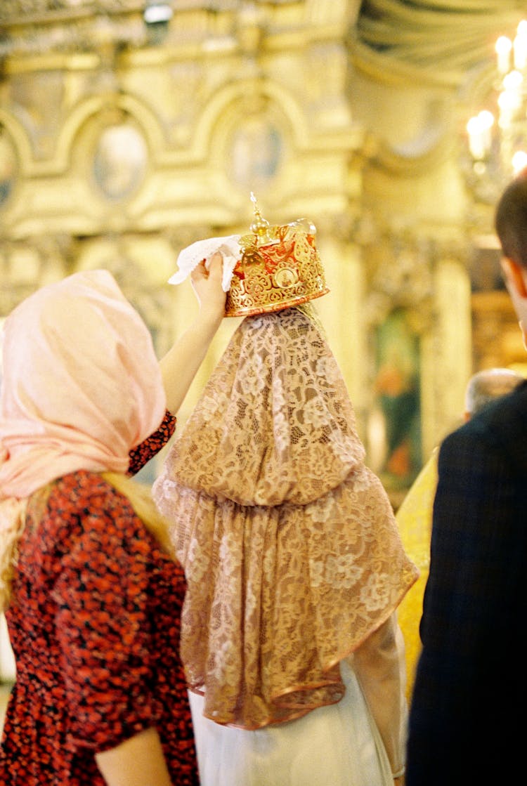 Woman Putting Crown On Top Of Orthodox Bride Head