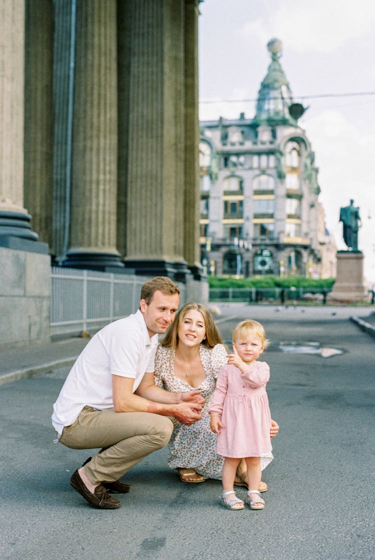 Parents Crouching At Little Girl In Town