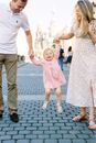 Mom and Dad Swinging their Cheerful Baby Daughter 