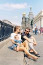 A Family Sitting on Concrete Pavement