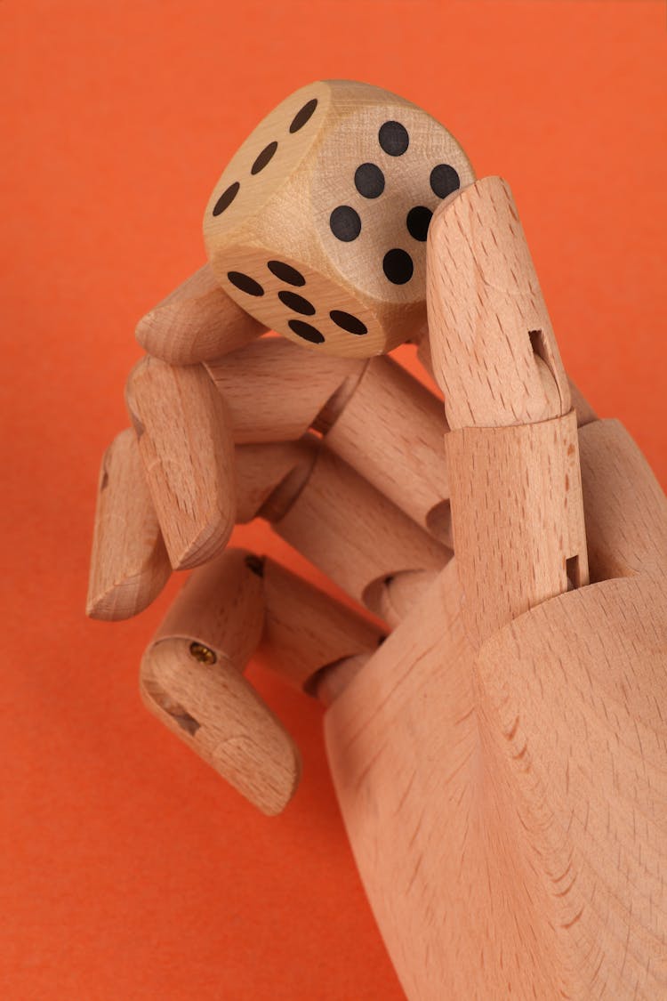 Photo Of A Wooden Die On A Mannequin Hand