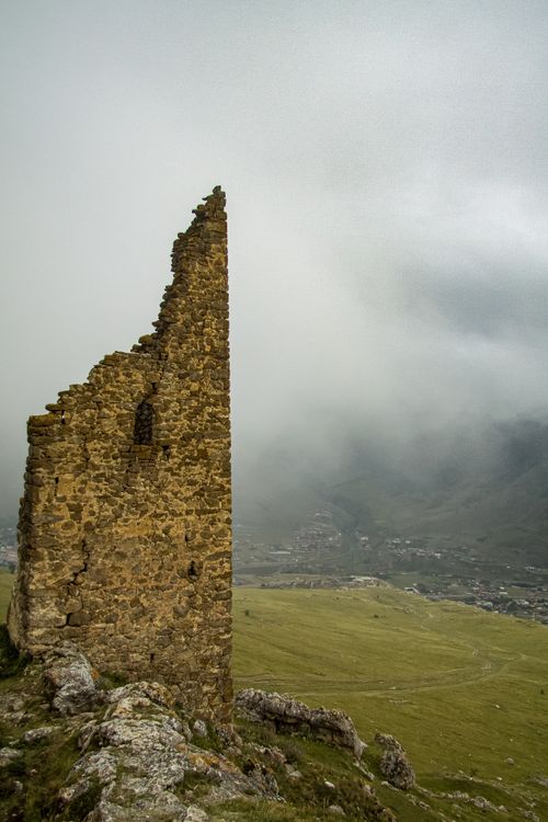 Free Ruins of a medieval tower amidst fog in North Ossetia-Alania, Russia. Atmospheric and historic. Stock Photo