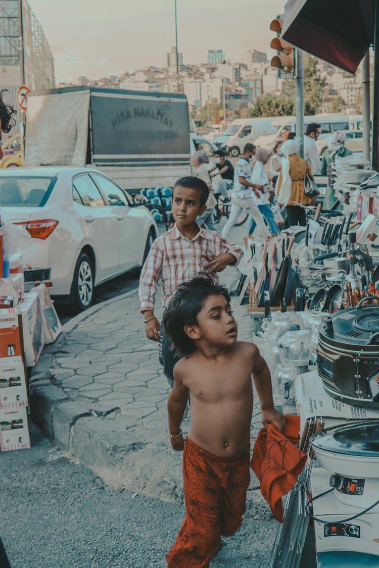 Kids Walking On The Side Of The Road Near Parked Cars