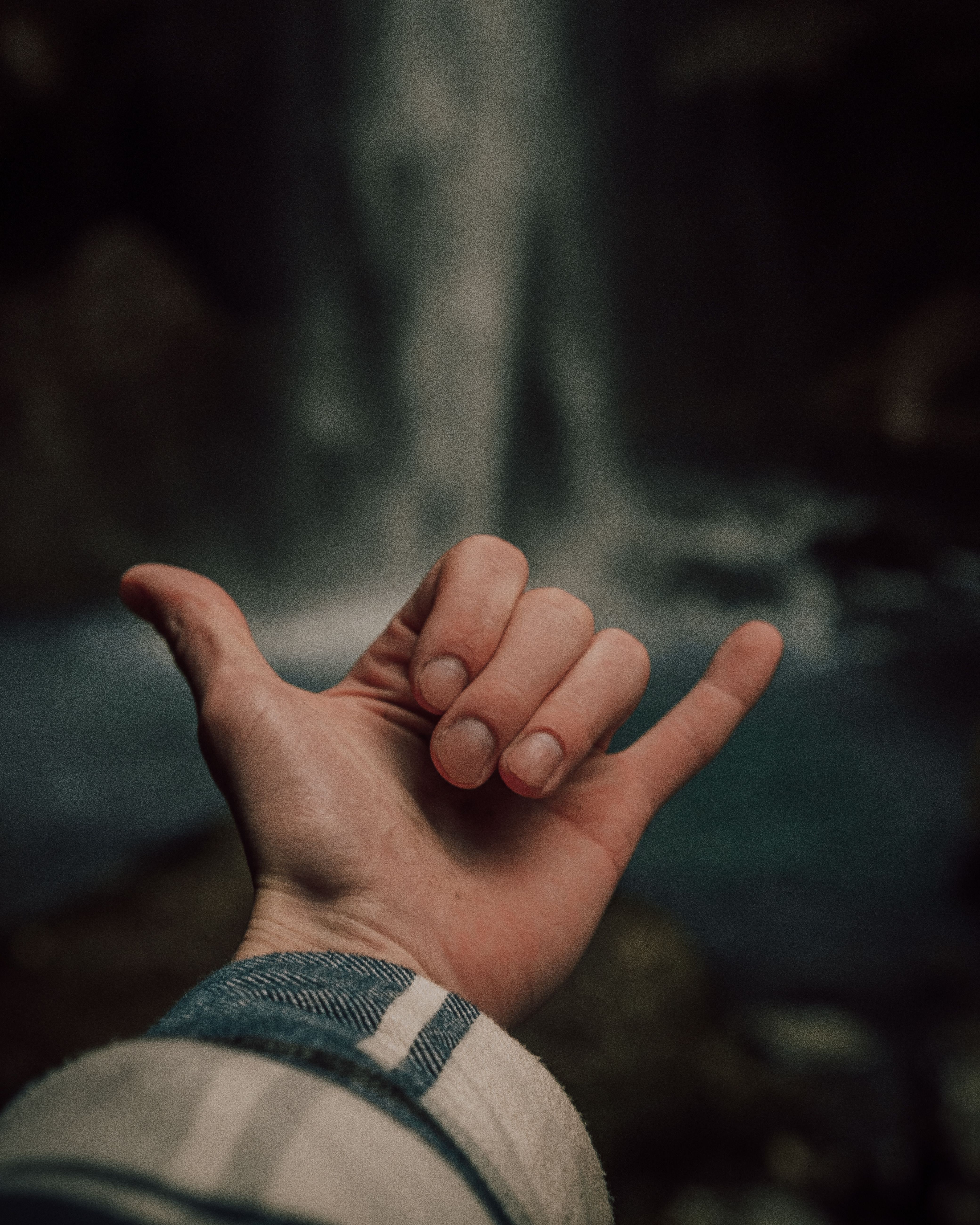 A Hand Sign in Close-up Photography with Waterfall Background · Free ...