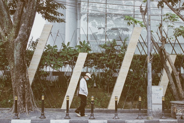 Side View Of A Man Walking On The Sidewalk