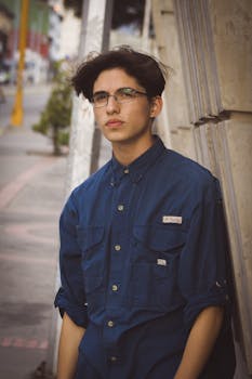 Portrait of a young Hispanic man leaning against a wall on a Venezuelan street.