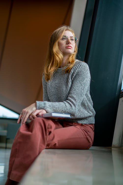 Woman in Gray Sweater Sitting Near Window