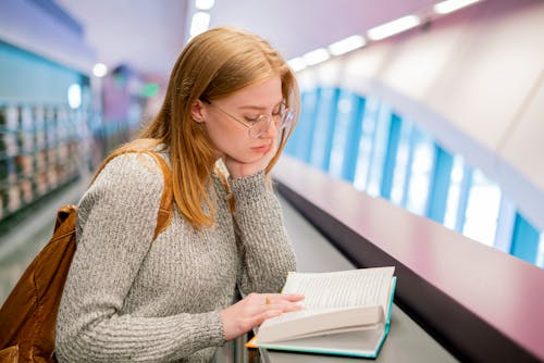 Woman in Gray Sweater Reading a Book