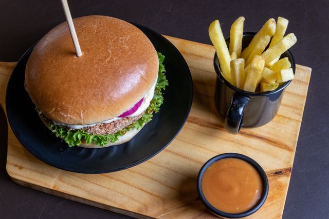 Burger et frites servis sur une planche en bois