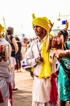 Colorful festival scene featuring traditional drummers in vivid attire playing instruments outdoors.
