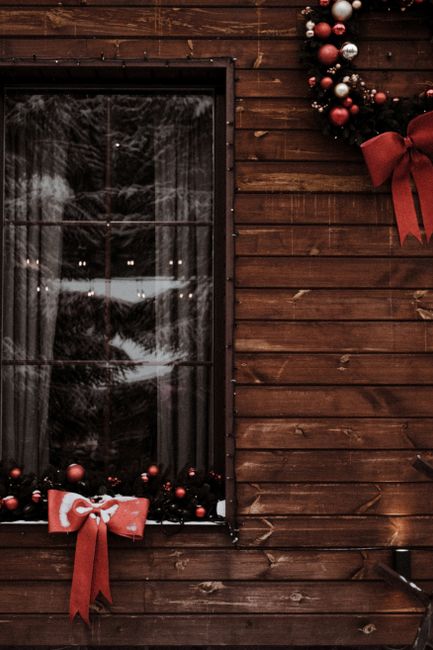 Festive Christmas wreath and decorations on a rustic wooden cabin wall in Bukovel, Ukraine.