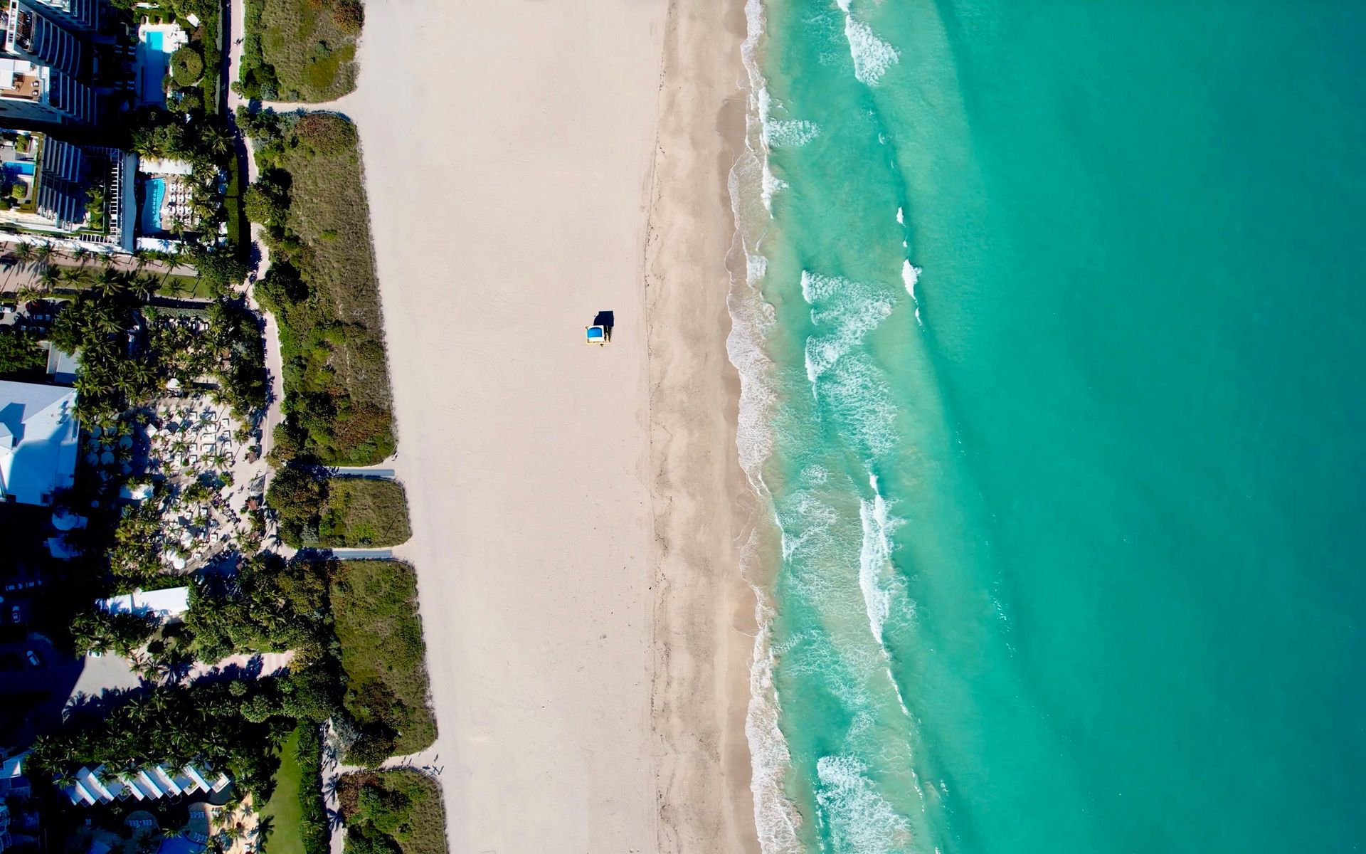 Stunning aerial view of Miami Beach's coastline, showcasing turquoise waters and sandy shorelines.