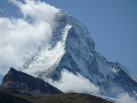 Explore the breathtaking beauty of the snow-capped Matterhorn peak surrounded by clouds.