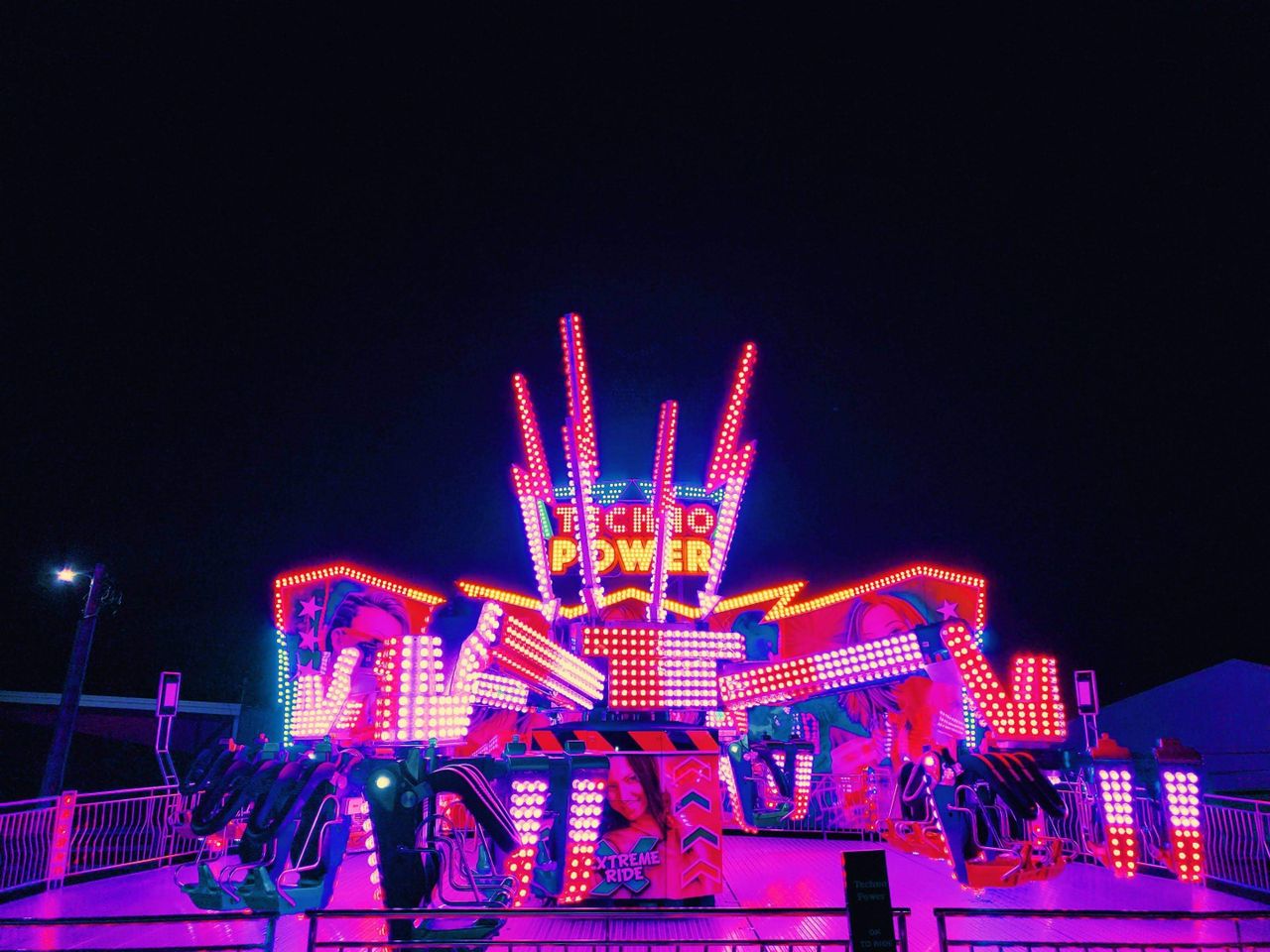 vibrant and illuminated amusement ride named techno power against a ni