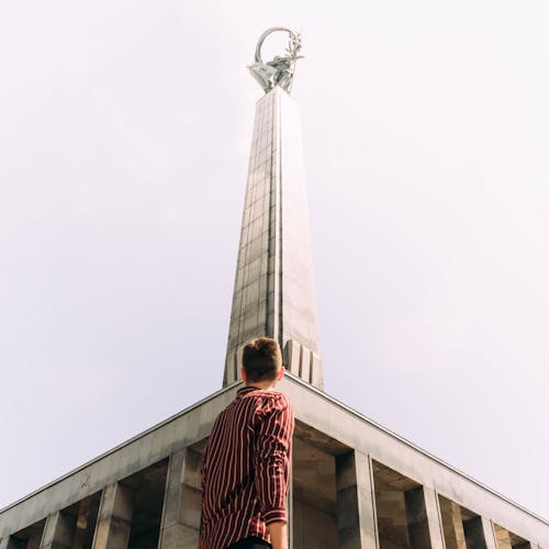 Man Standing in Front of Gray Concrete Tower