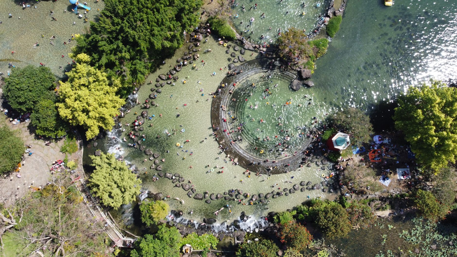 Aerial shot of Suoi Mo Park with people enjoying water activities in a lush setting.