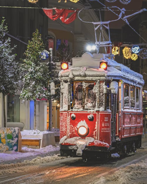 A Snow Capped Tram on the Street at Night