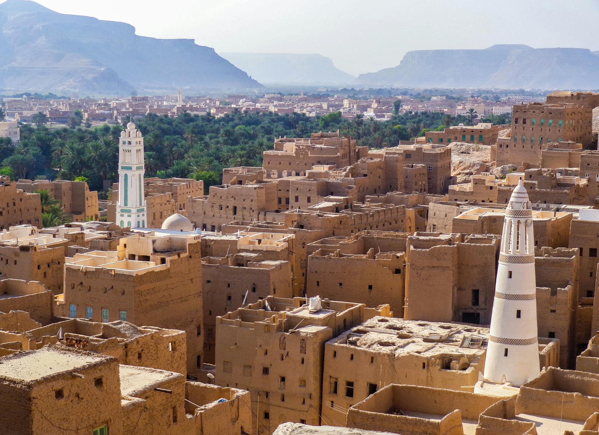 Aerial view showcasing the traditional architecture of a historic town in Yemen with iconic towers and desert landscape.