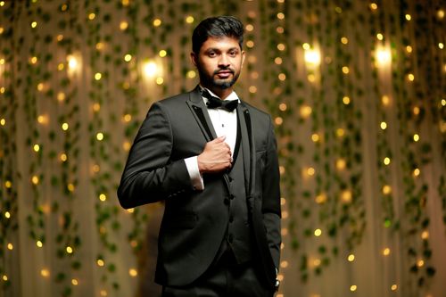 Free Elegant portrait of a stylish man in a black suit with a captivating bokeh background. Stock Photo