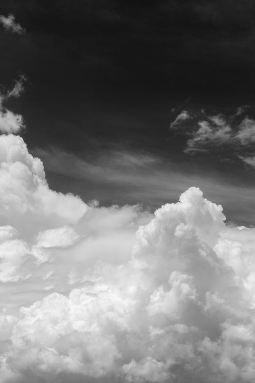 Free Dramatic monochrome sky with fluffy white clouds creating contrast against a dark backdrop. Stock Photo