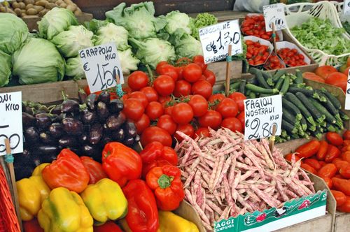 Free Colorful variety of fresh vegetables displayed at an outdoor market stall with price signs. Stock Photo