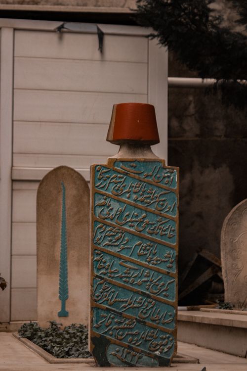 Free A vertical shot of a decorated Arabic tombstone with inscribed writings, symbolizing memory and religion. Stock Photo