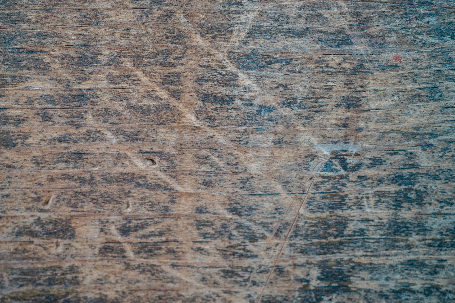 Detailed close-up of a textured wooden surface with scratches and marks.