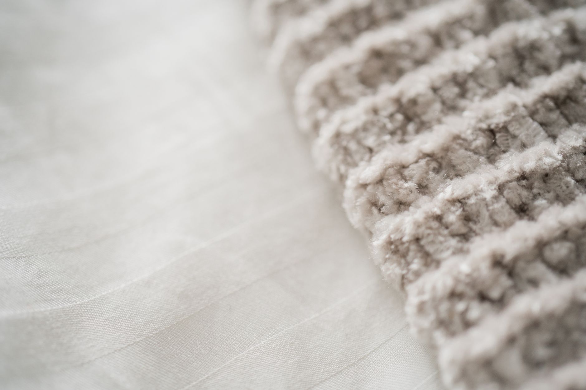Detailed close-up of a white textured fabric with thick wool fibers for textile design inspiration.