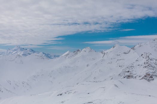 A breathtaking view of a snow-covered mountain range beneath a clear blue sky.