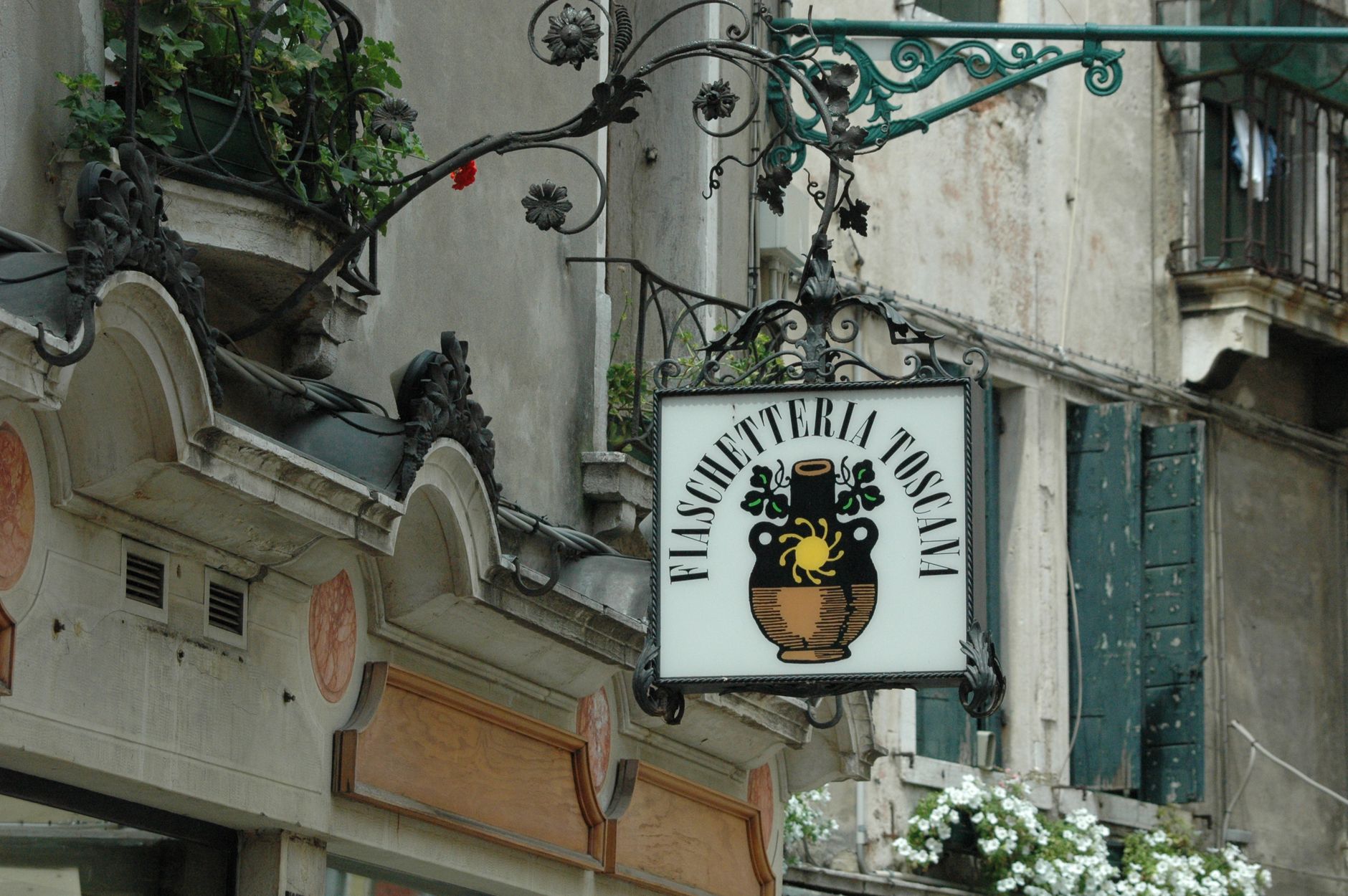 Ornate 'Fiaschetteria Toscana' sign on a historic European building exterior.