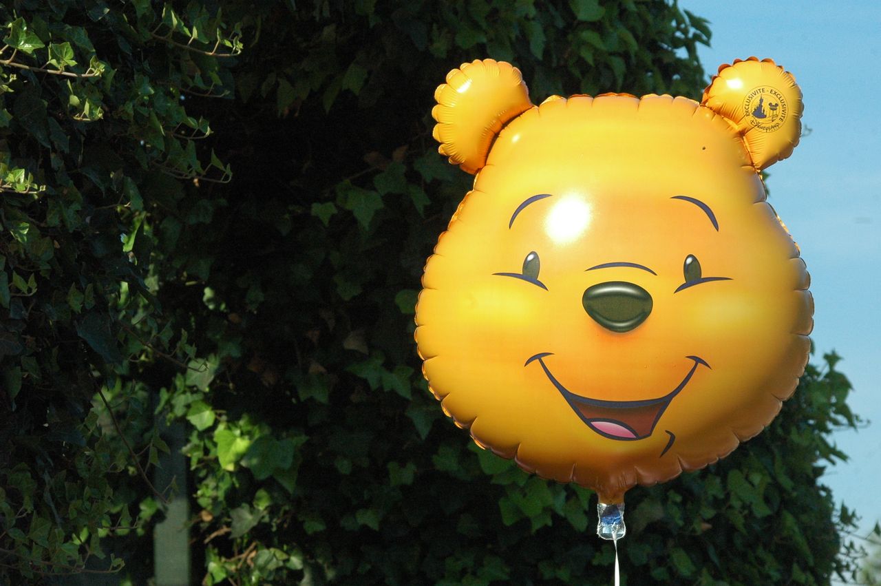 a vibrant yellow balloon shaped like a cartoon character set against l