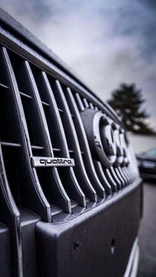 Free Macro image of a car grille focusing on the quattro badge, showcasing automotive detail. Stock Photo