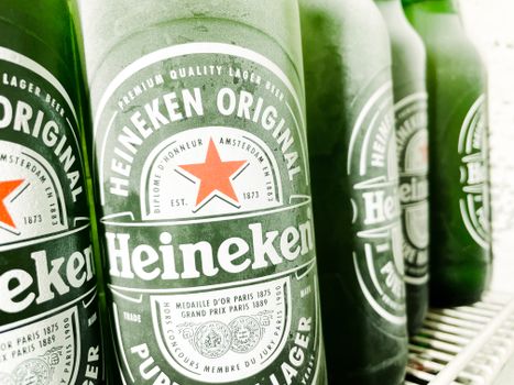 Chilled Heineken beer bottles neatly arranged in a refrigerator, ready to enjoy.