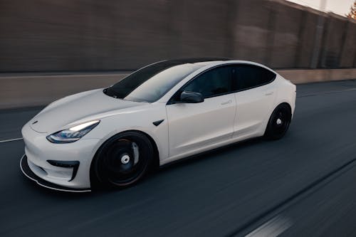 A White Tesla Car on a Road 