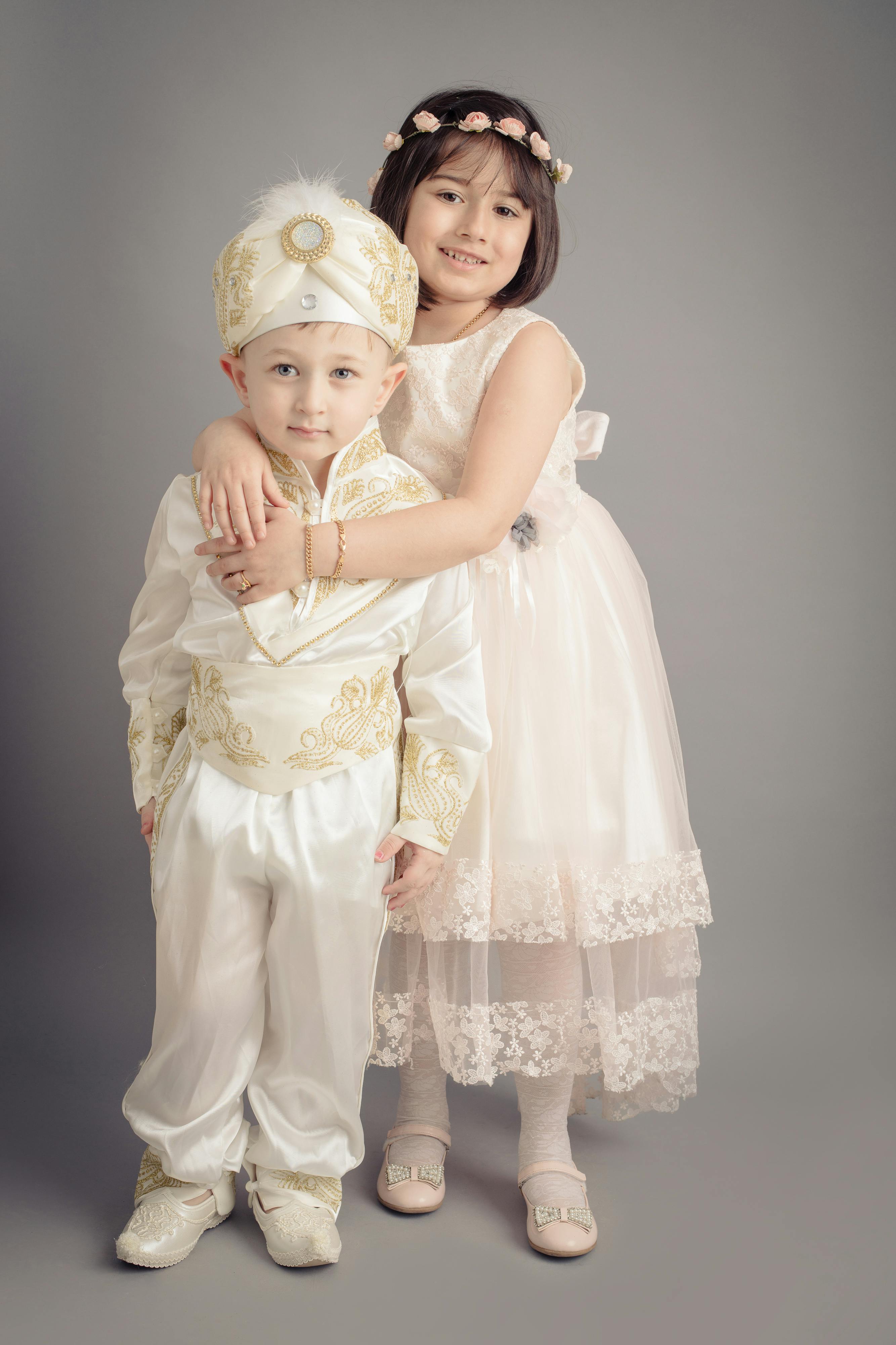 woman in white floral dress carrying baby in white dress