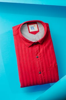 A vibrant red polo shirt neatly folded on a striking blue surface, captured from above.