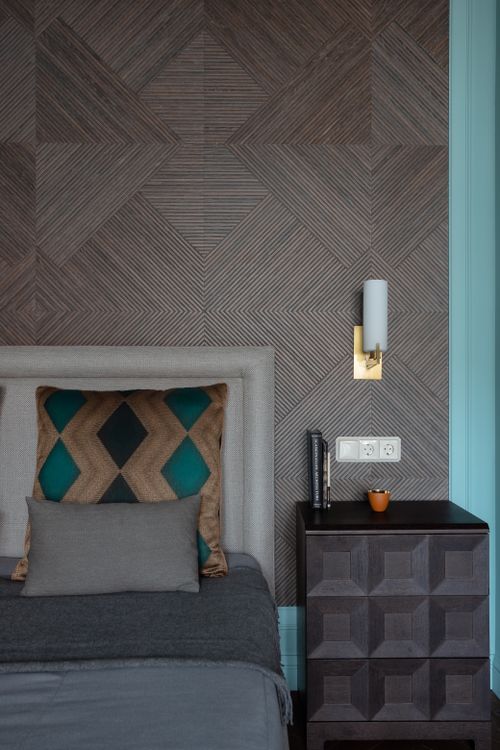Free Stylish bedroom in Saint Petersburg featuring geometric wall patterns, cozy bed, and side table. Stock Photo