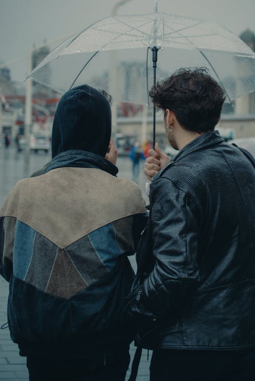 Back View of People Under an Umbrella