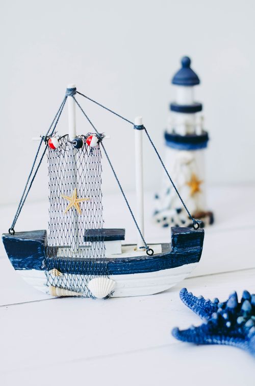 Free Charming nautical-themed decor with a model boat, starfish, and miniature lighthouse. Stock Photo