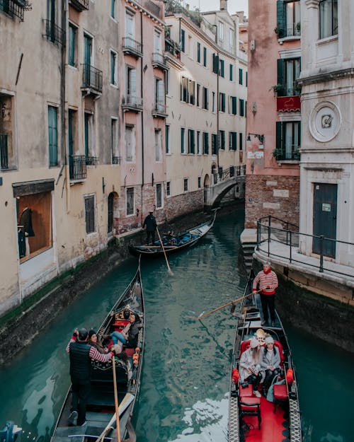 People Riding on Gondolas on the Grand Canal Between Buildings