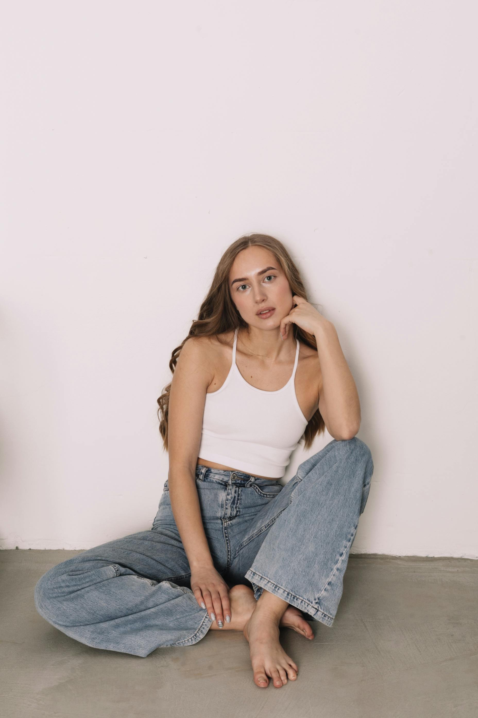 A Woman Wearing a White Tank Top and Denim Jeans · Free Stock Photo